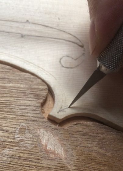 Lightly tracing the outlines of the purfling slot, with a thin, sharp blade.