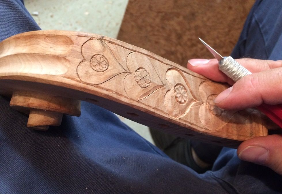 Five-string cello scroll carving process.